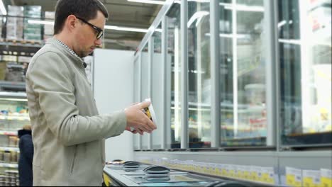 man looking at frozen food in a supermarket