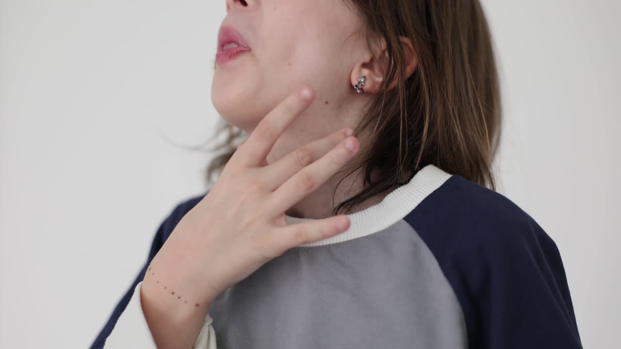 Young person scratching their neck due to itching or discomfort