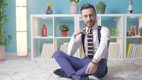 Handsome-attractive-stylish-dressed-man-sitting-on-floor-at-home-looking-at-camera-and-looking-cool.