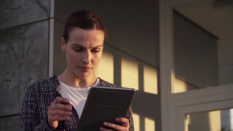 Confident-entrepreneur-with-tablet-on-city-street