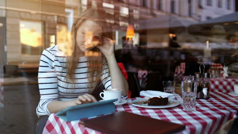 Frau-Im-Café-Benutzt-Tablet-PC-Und-Isst-Dessert