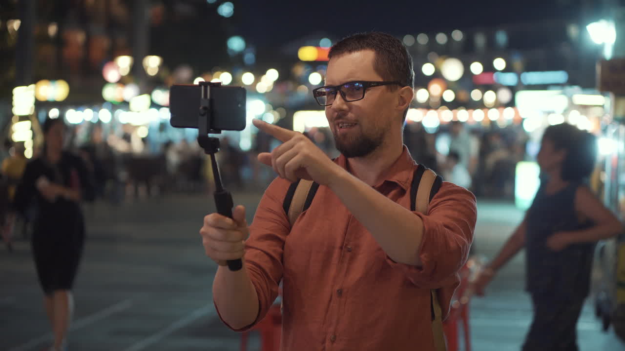 hombre vlogging en un mercado nocturno