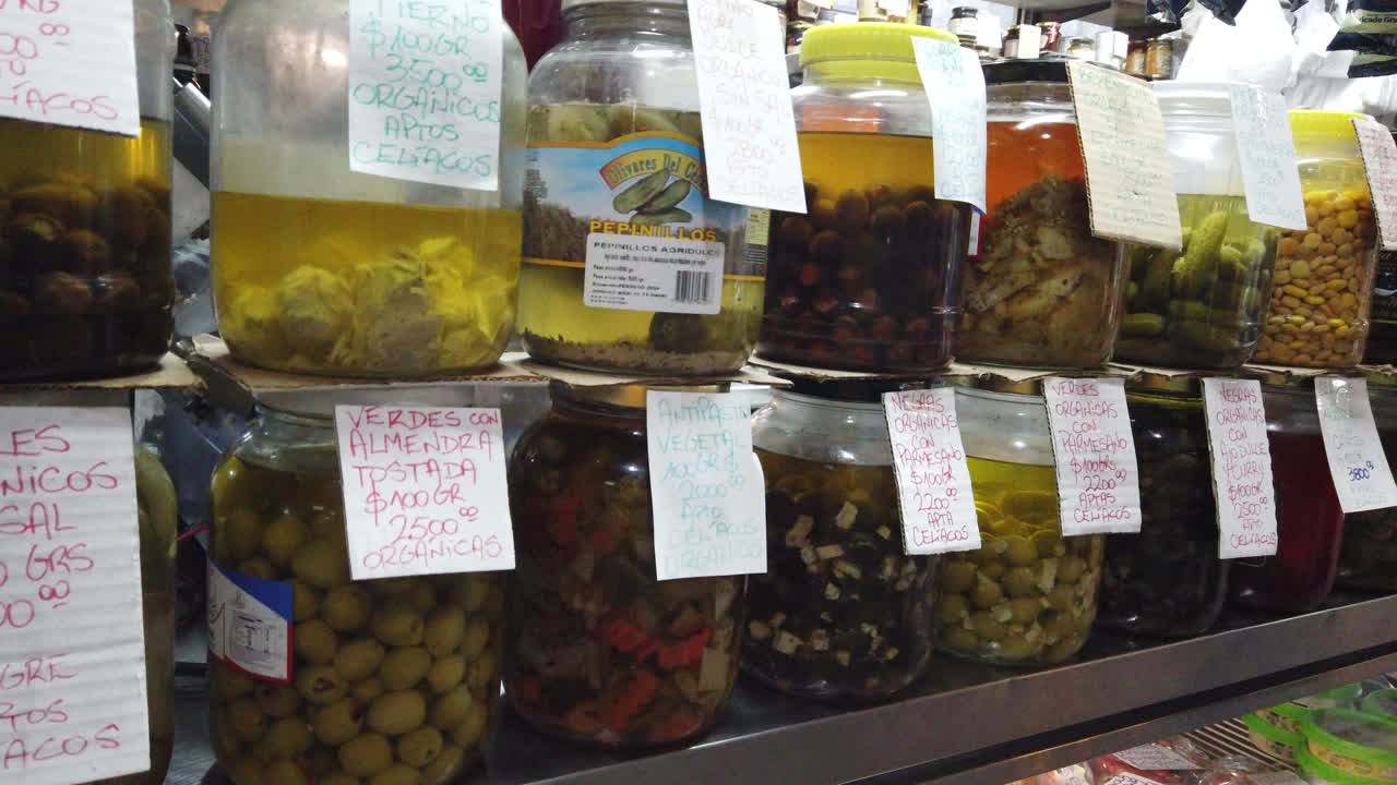 Closeup shot at olives oil and fermented products with Argentine currency marketplace