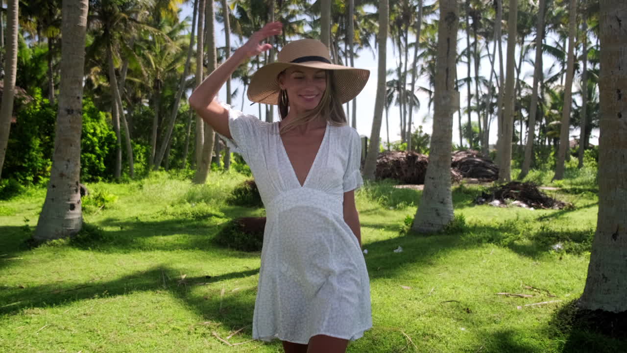 Mujer con un vestido blanco y sombrero de paja en un entorno tropical