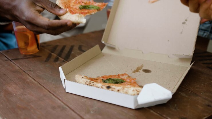 Primo piano di pizza dentro una scatola di cartone