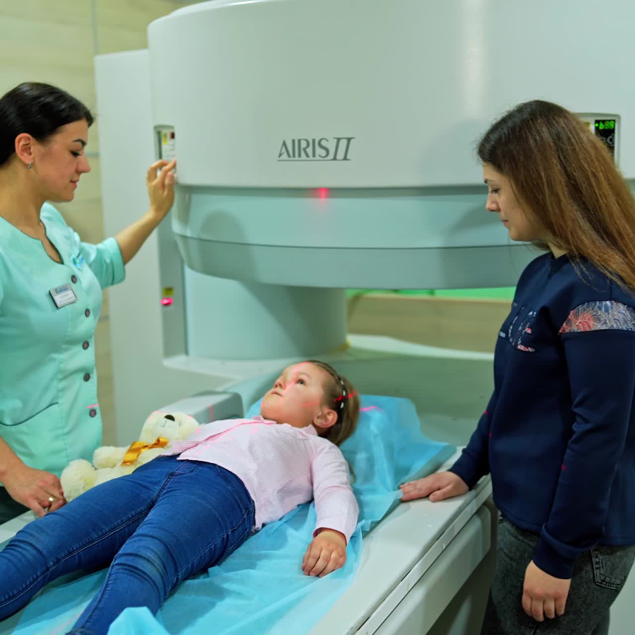 Una bambina in età prescolare si sottopone a un controllo allo scanner MRI. Il medico accende l'apparecchiatura ed esce dalla stanza