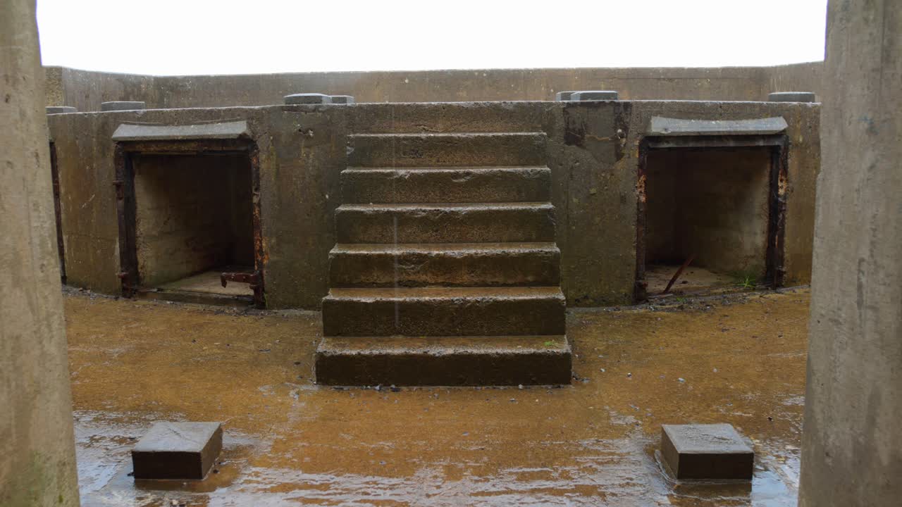 Journey through the remnants of Brean Down Fort, showcasing its weathered structure and moss-covered steps against a dramatic coastal backdrop. The atmosphere evokes a sense of history and mystery.