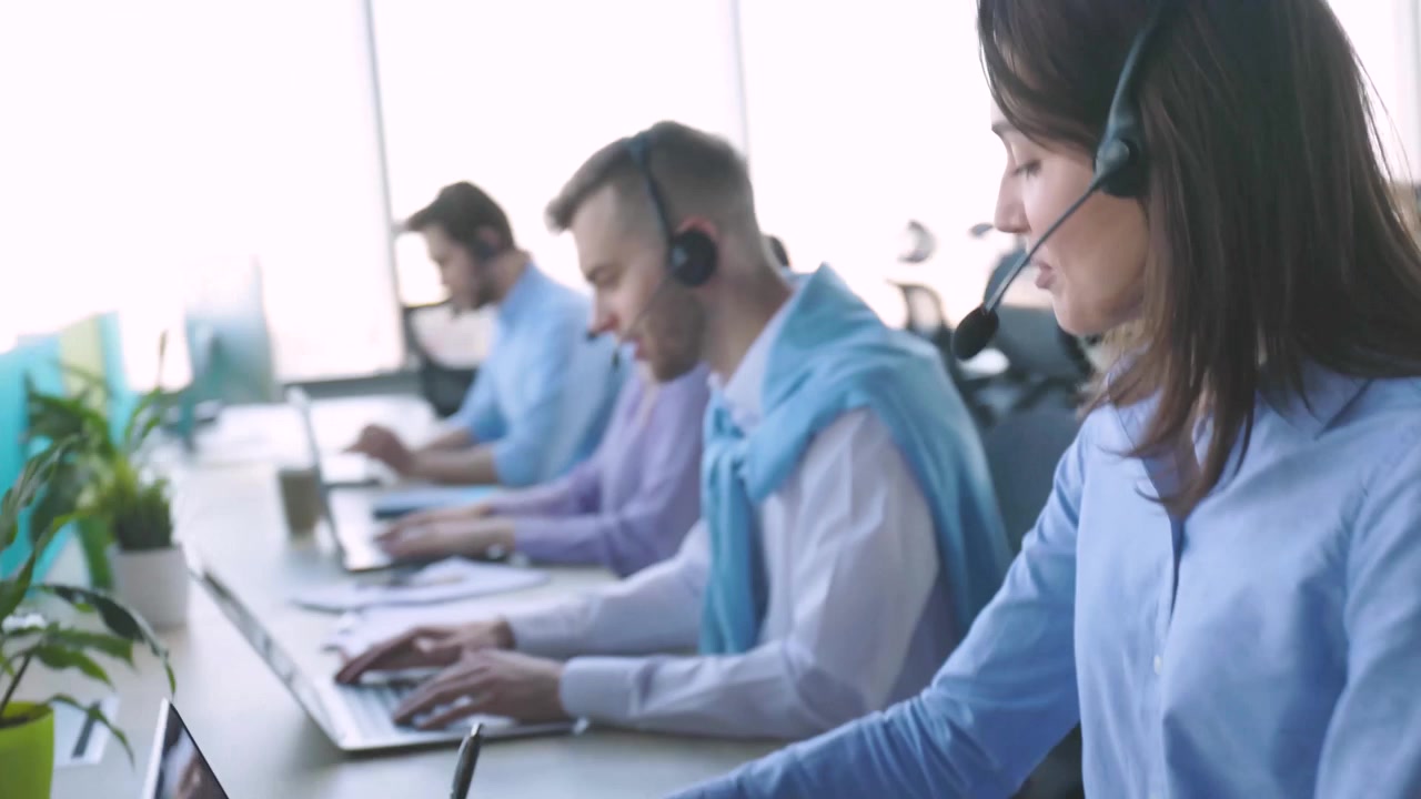 Customer Service Agents Working with Headsets in Modern Office