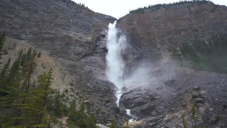 gran cascada revelada a través de los árboles y que fluye hacia abajo de una montaña creando rápidos a medida que continúa fluyendo hacia abajo de la montaña
