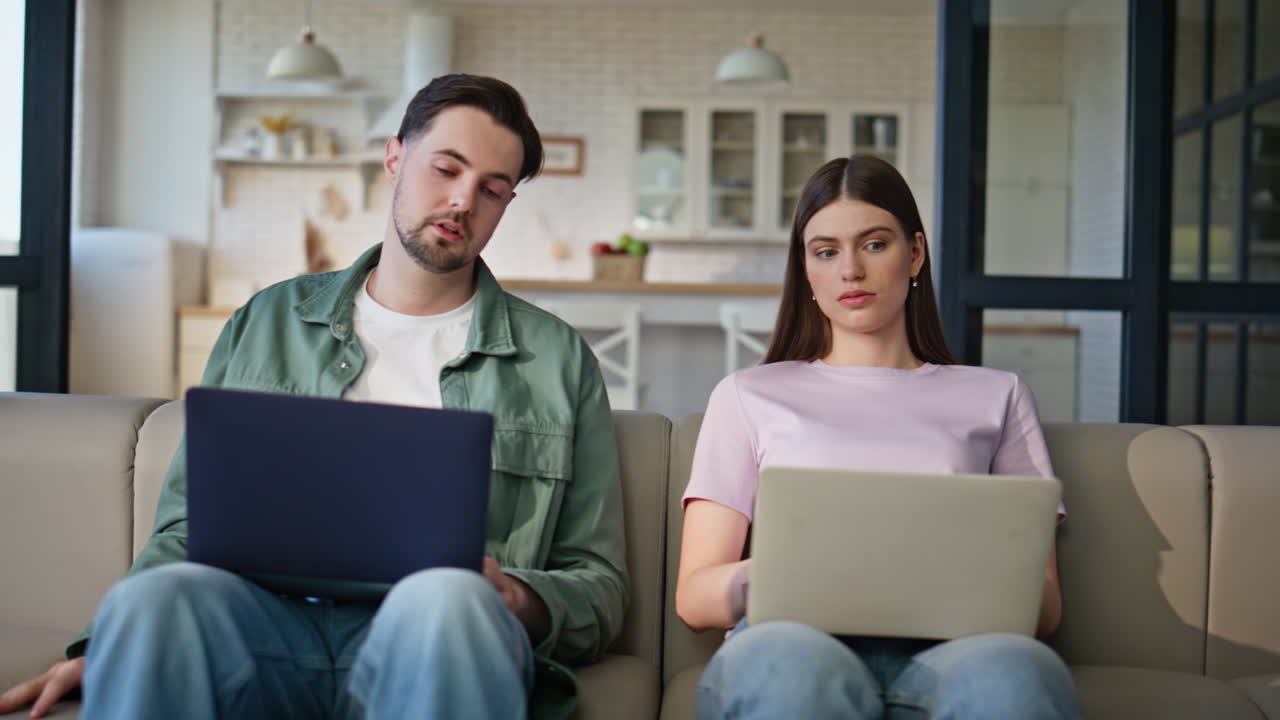 Remote workers texting laptops at living room interior closeup. Man yawning