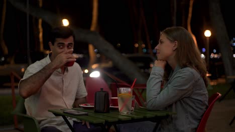 pareja disfrutando de café al aire libre por la noche