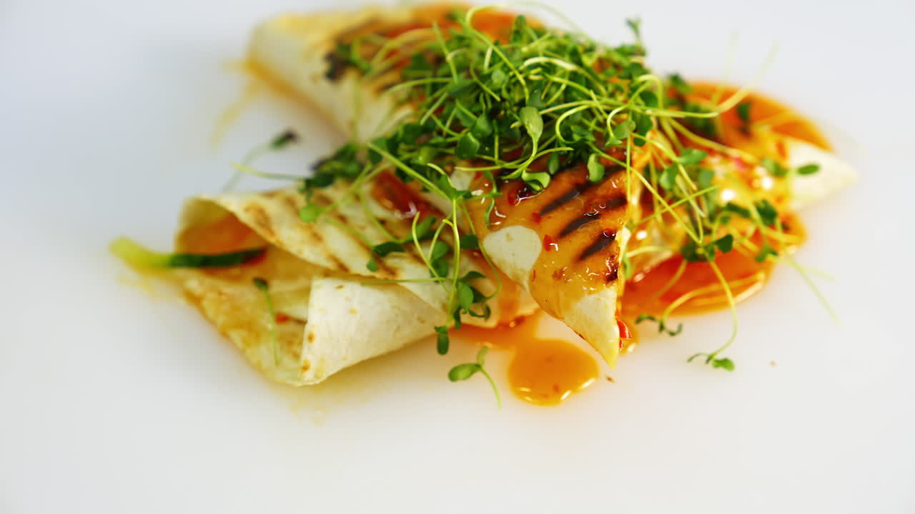 Fry pita bread on white plate. Shawarma fried on grill with microgreen on top. Tasty street food video.