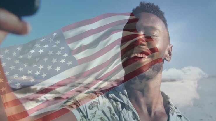Man pressing phone shutter and fading US flag overlay while swiping travel selfie on sunny beach