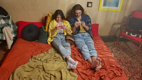 couple relaxing and playing games in a cozy bedroom