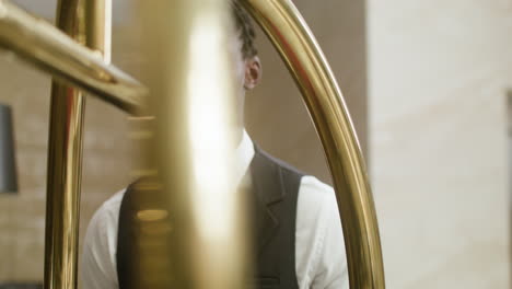 bellhop carrying a hotel cart with luggage