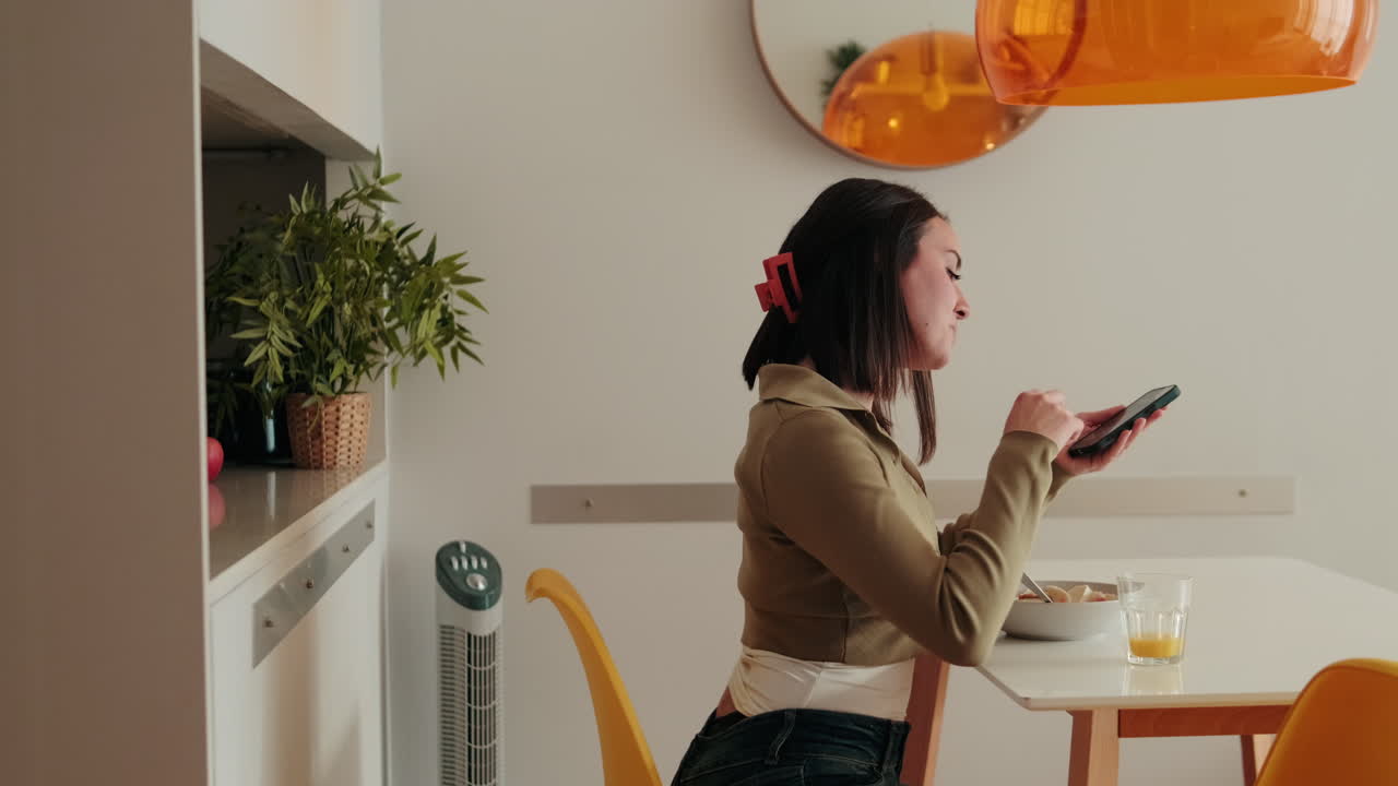 Side view of Woman Enjoys Breakfast and Smartphone