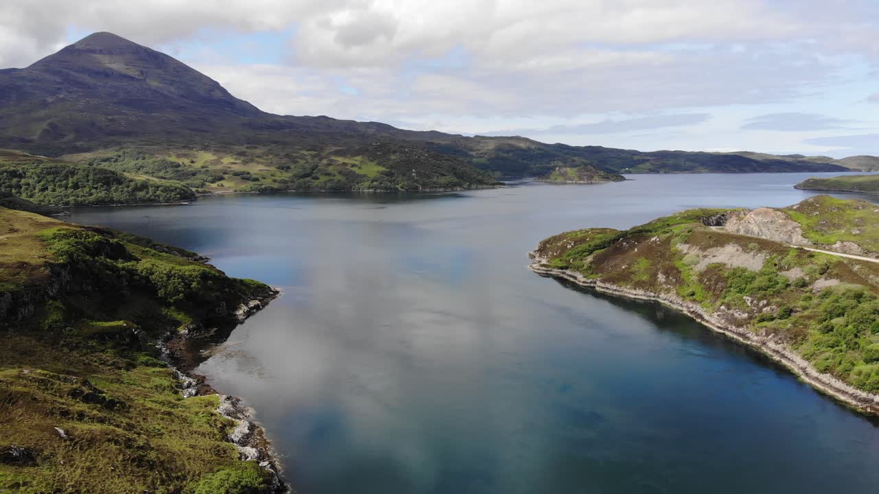 Low Drone Aerial fast pan at Kylesku. Kylesku Bridge, Loch a' Chairn Bhain then followed by Mountains of Quinaig in background. (June 2019)