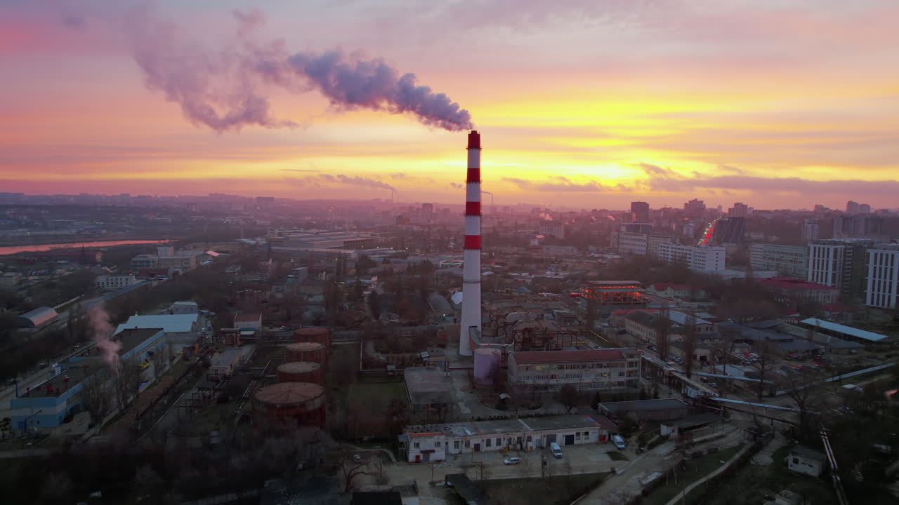 Aerial drone view of thermal power plant in Chisinau at sunrise, Moldova. View of pipe with felling steam, cityscape