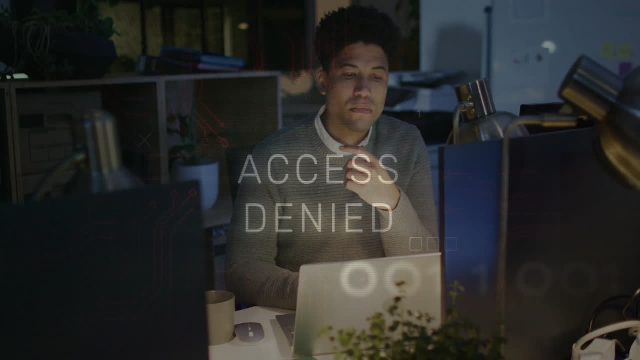 Access Denied animation overlay while man working on laptop in office