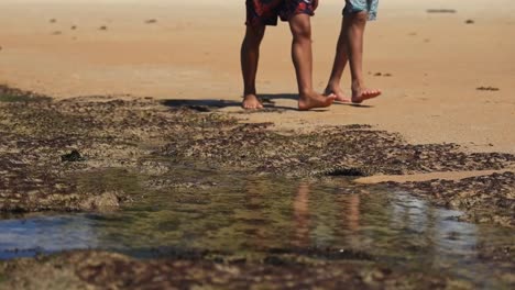 beach scene. low pov showing male legs walking on sand. static