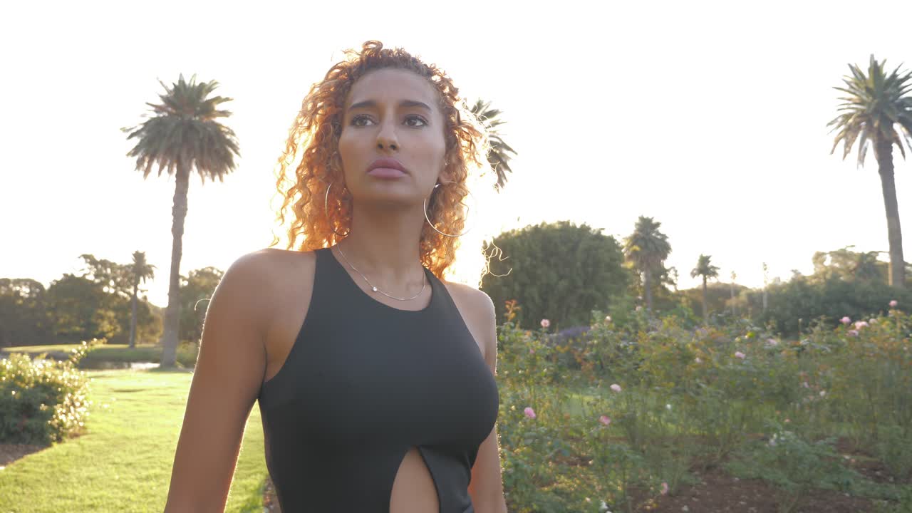 uma garota bonita e sexy andando em um jardim de flores em saint andre, bélgica em um dia ensolarado - plano médio