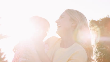 mother playing in garden at home with daughter