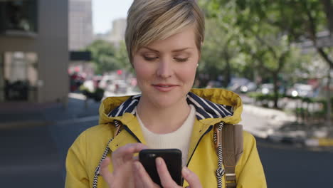 Retrato-De-Una-Hermosa-Mujer-Rubia-Parada-En-La-Acera-Enviando-Mensajes-De-Texto-Navegando-Usando-Un-Teléfono-Inteligente-Disfrutando-De-Un-Viaje