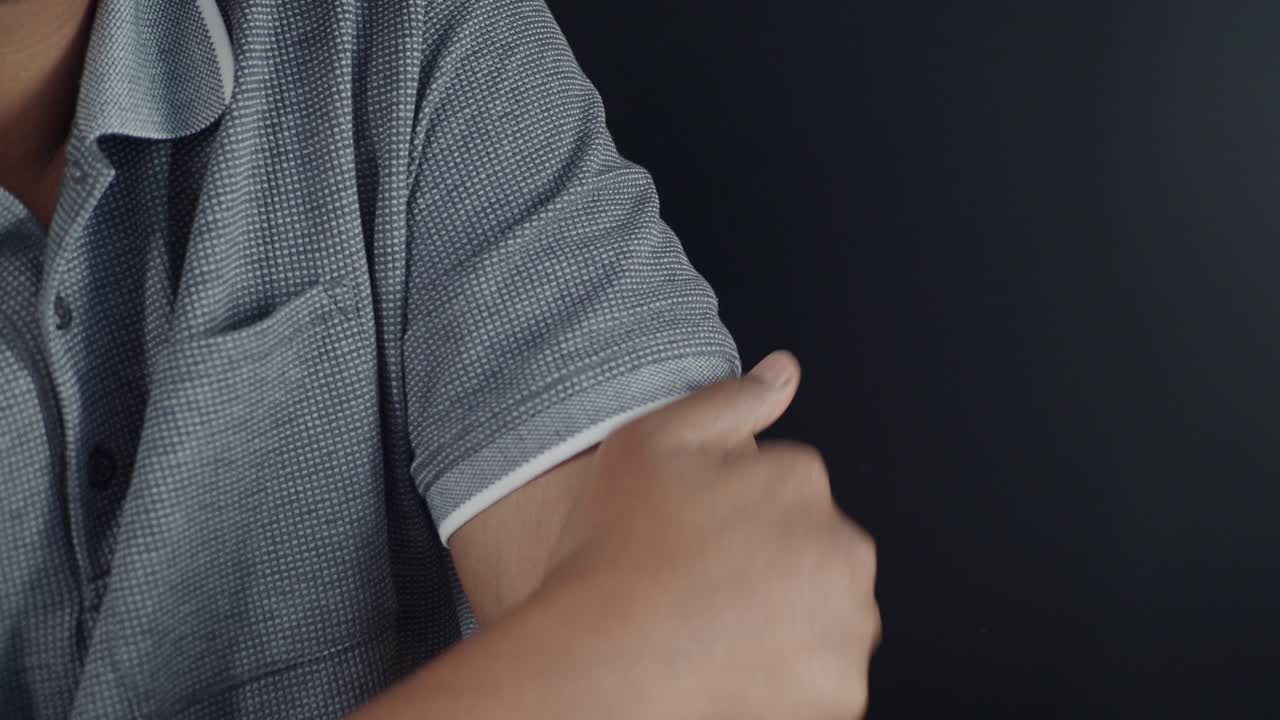 남자가 그의 팔 부분을 만지고 있습니다.