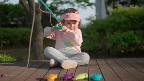 Niña-De-3-Años-Jugando-Al-Juego-De-Pesca-Al-Aire-Libre-Al-Atardecer