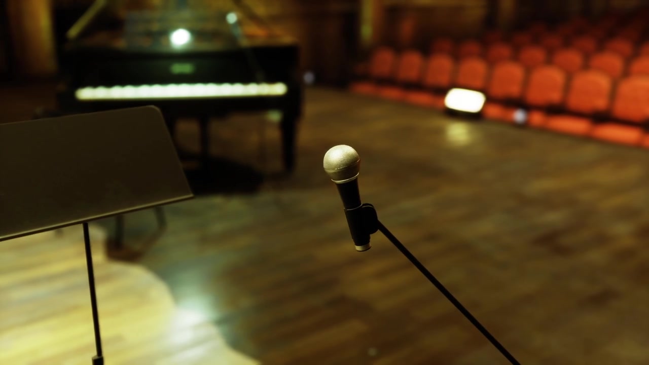 Microfono orientato verso gli spettatori vicino a un pianoforte a coda.