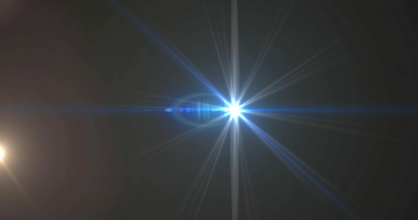 Un bagliore caldo proveniente da sinistra crea un riflesso dell'obiettivo e un alone arcobaleno che si espande, spostandosi verso destra e rivelando artefatti della lente.