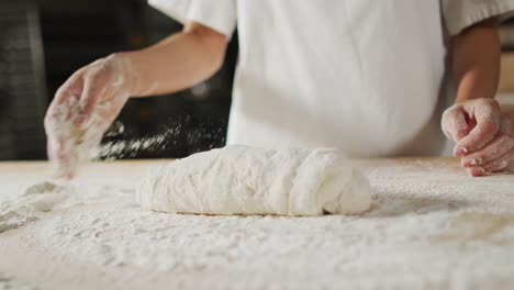 animation of hand of asian female baker preparing sourdough for bread