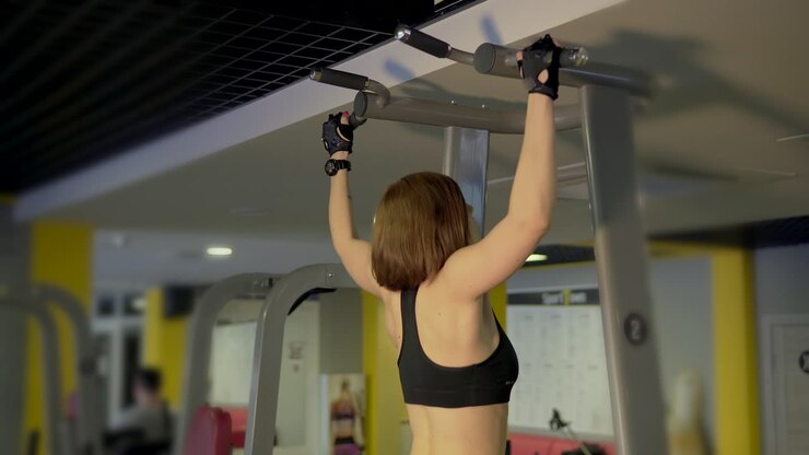 Woman Doing Pull-Ups in a Gym