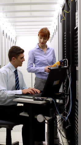 technicians using digital cable analyzer on server