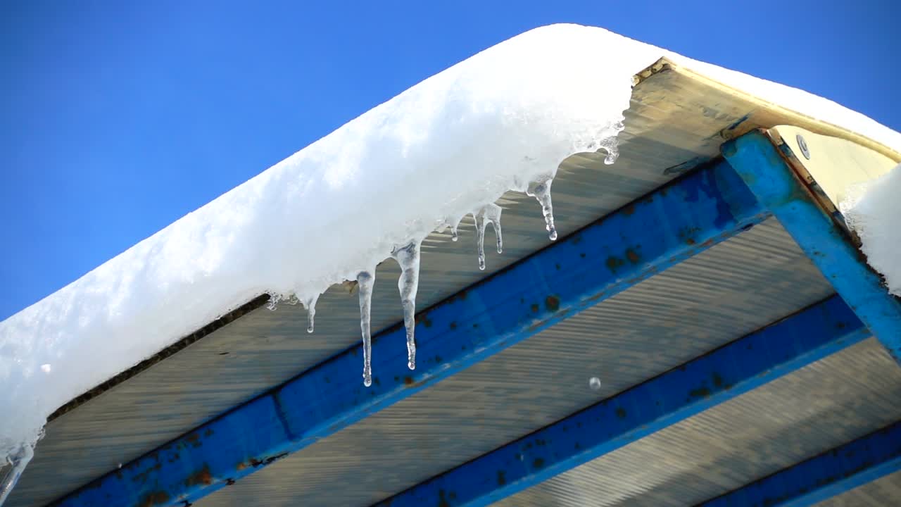 The water dripping from icicles. Shooting in the winter. Slow motion