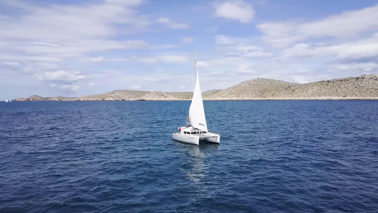 Catamaran Sailboat sailing on the Blue sea - Aerial Drone View