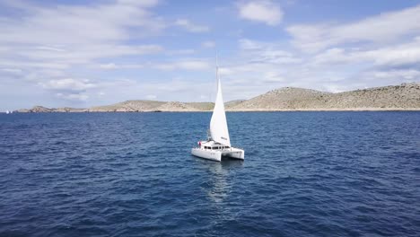 catamaran sailboat sailing on the blue sea - aerial drone view