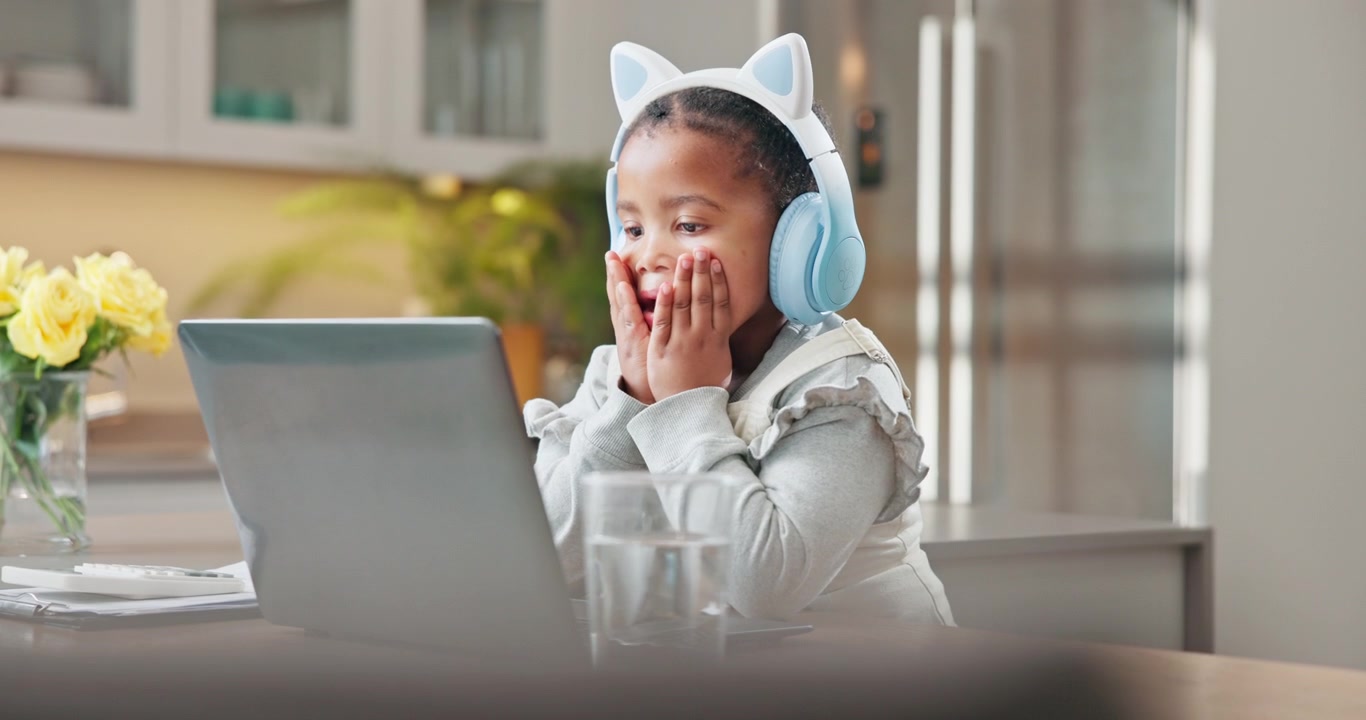 Young Girl Wearing Cat Ear Headphones Watching Laptop at Home