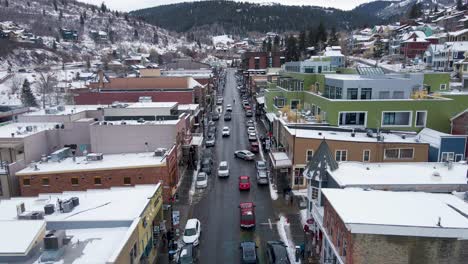 Vehículos-Circulando-Por-La-Carretera-Asfaltada-De-La-Calle-Principal-Con-Edificios-Típicos-Durante-El-Invierno-En-Park-City,-Utah,-Ee.uu.