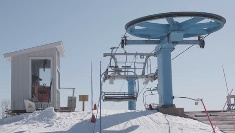 empty ski chairlift in operation on top of snowy mountain, slow motion