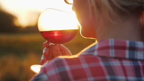 Frau-Riecht-Rotwein-Bei-Sonnenuntergang