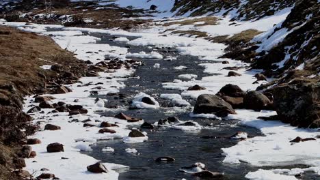 un río que fluye a través de un paisaje cubierto de nieve y hielo a principios de la primavera