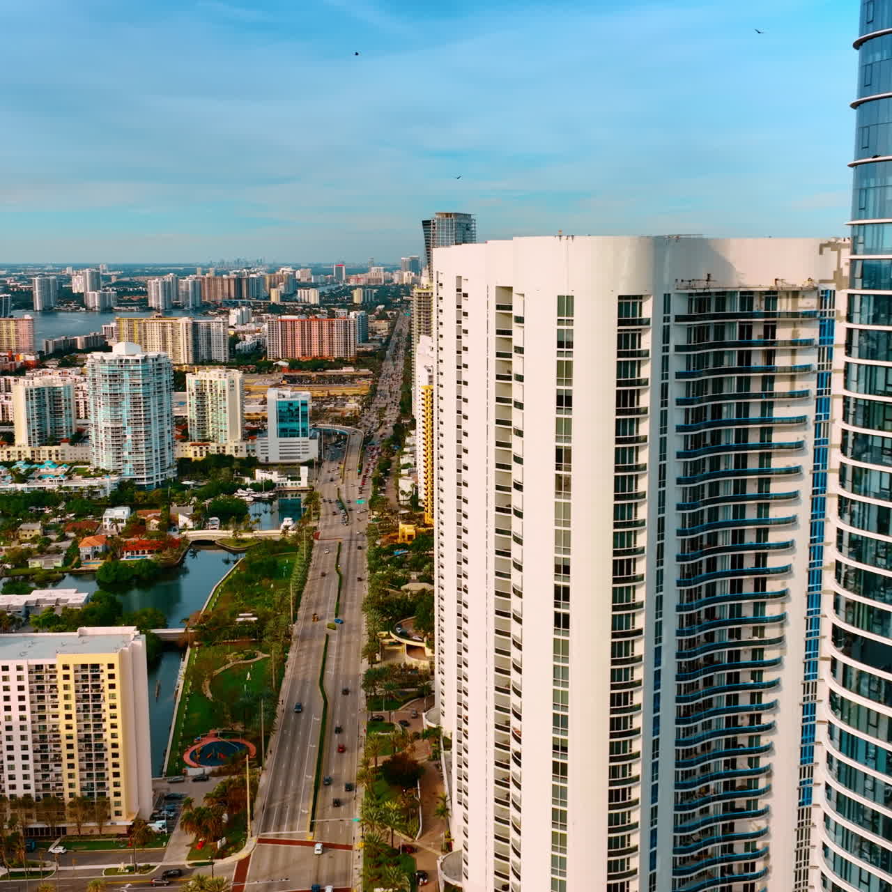 Splendid view of Miami Beach on sunny daytime. Drone flying at the tops of skyscrapers built on the coast of the Atlantic Ocean.