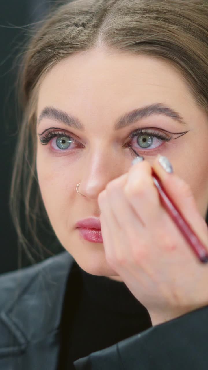 mujer aplicando eyeliner
