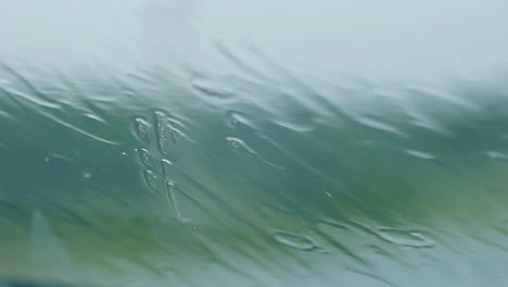 close view raindrops fall on glass running with water drips