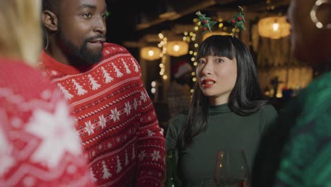 Tracking-Shot-Revealing-a-Small-Group-of-Friends-Celebrating-Christmas-at-a-Bar