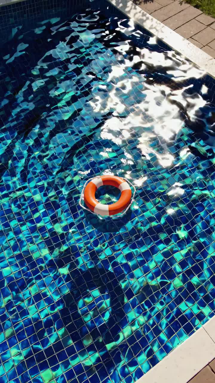 Bidikan video dari atas ke bawah dari kolam renang yang ramai dengan pelampung mengambang