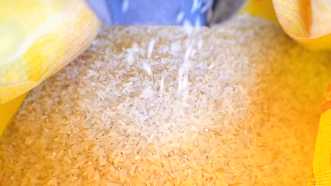 cerca del arroz paddy que fluye en el saco amarillo