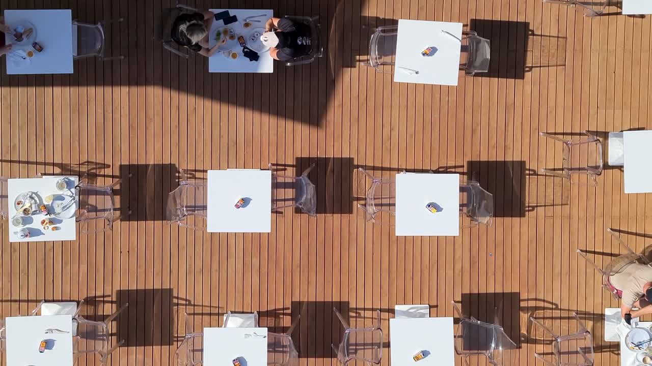 사람들이 먹고 마시는 아침 식사용 테이블이 늘어서 있다