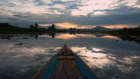 viejo arco de madera navegando en un lago idílico con reflejo de espejo